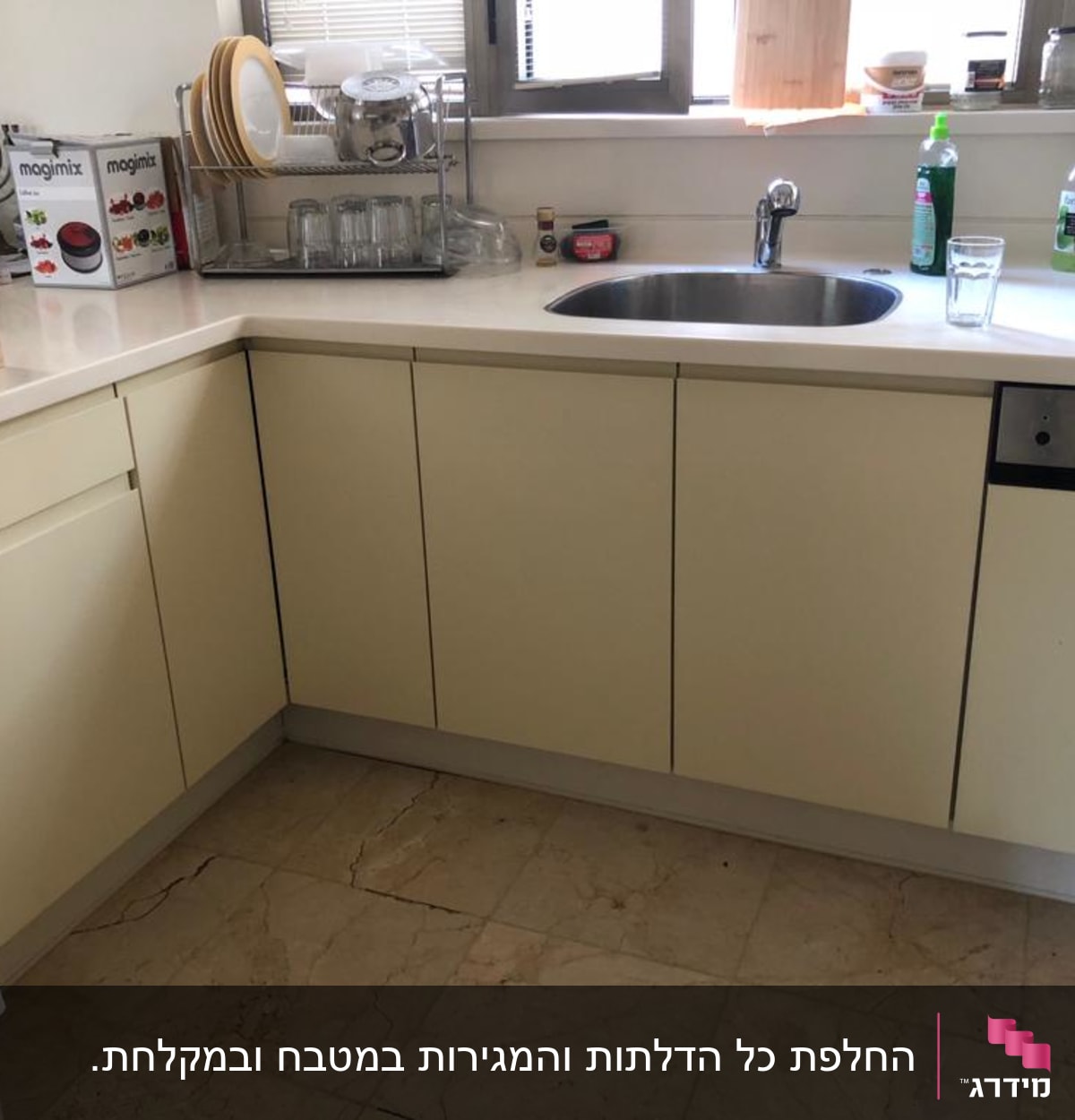 מטבח עם ארונות, כיור וברז, כלים על השיש